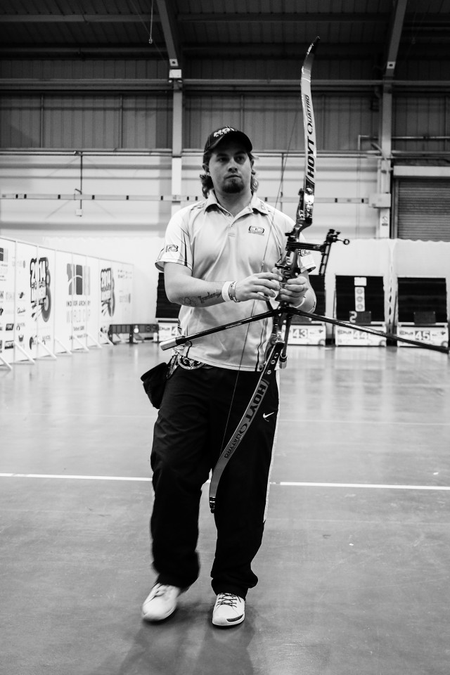 Man holding bow arrow building free wallpaper for mobile - medium preview image