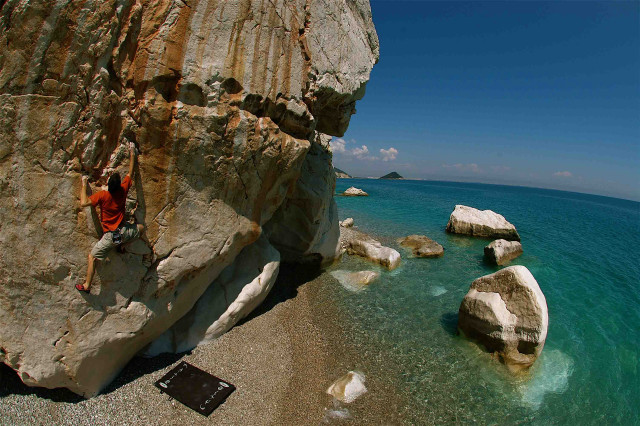 Man climbing cliff ocean beach free wallpaper for desktop - medium preview image