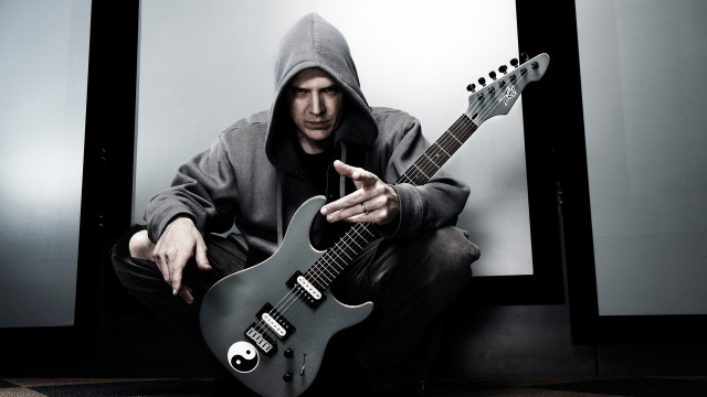 Man hoodie guitar pointing camera free wallpaper for desktop - medium preview image