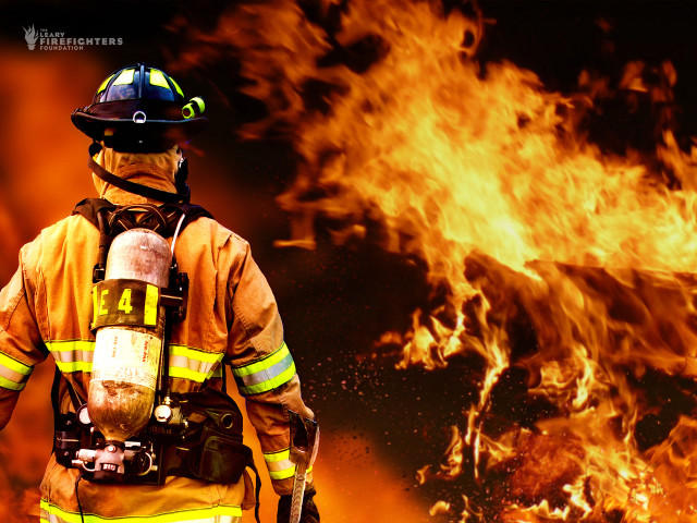 Firefighter standing front fire background #2 free wallpaper for desktop - medium preview image