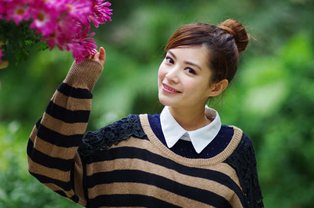 Woman holding flowers smiling camera free wallpaper for desktop - medium preview image