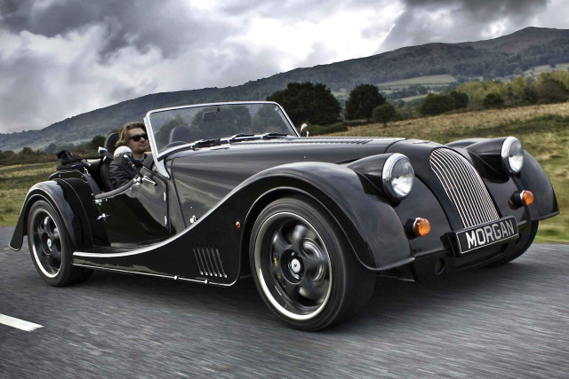 Vintage black sports car driving free wallpaper for desktop - medium preview image