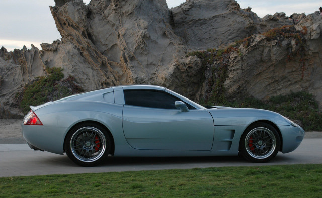 Silver sports car rock formation free wallpaper for desktop - medium preview image