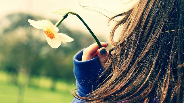Woman holding flower looking blurry free wallpaper for desktop - medium preview image