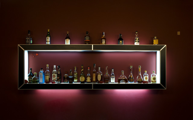 Shelf liquor bottles red wall free wallpaper for desktop - medium preview image