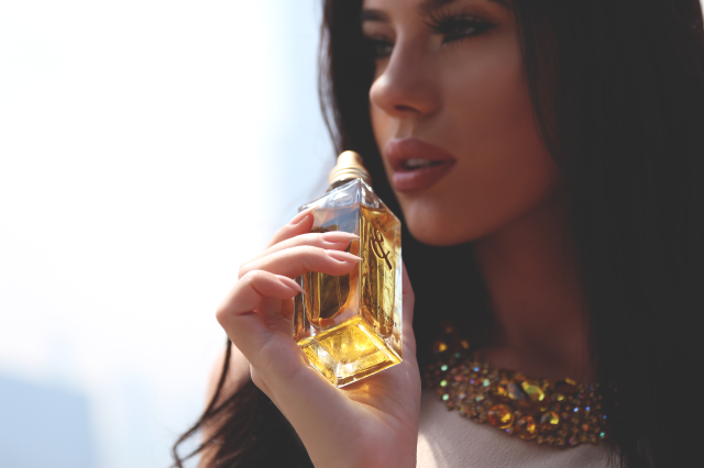Woman holding perfume bottle serious free wallpaper for desktop - medium preview image