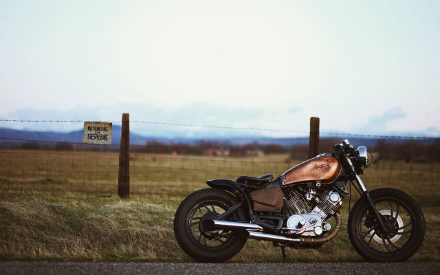 Motorcycle parked road fence field free wallpaper for desktop - medium preview image