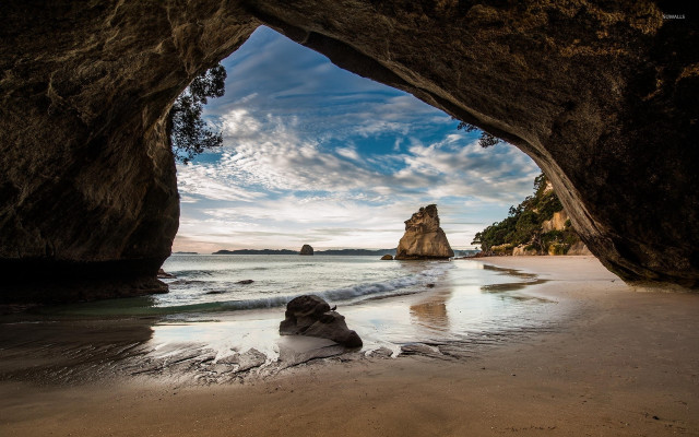 Beach cave person cloudy ocean free wallpaper for desktop - medium preview image