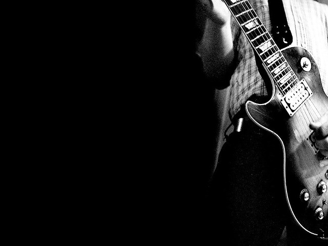 Man holding guitar serious look #3 free wallpaper for desktop - medium preview image