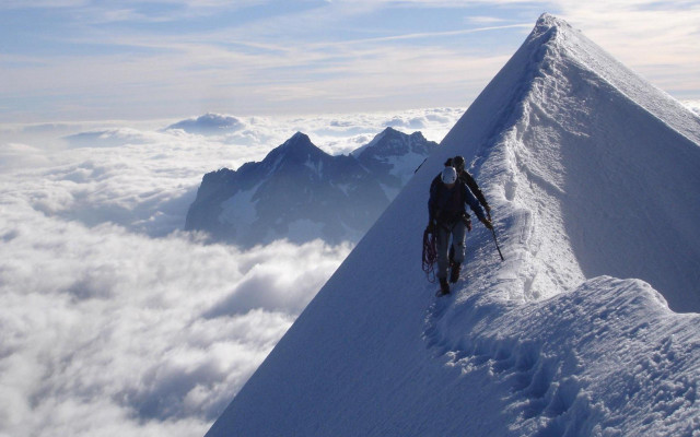 Man climbing snow covered mountain free wallpaper for desktop - medium preview image