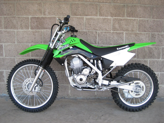 Green dirtbike brickwall sidewalk blacktire free wallpaper for desktop - medium preview image