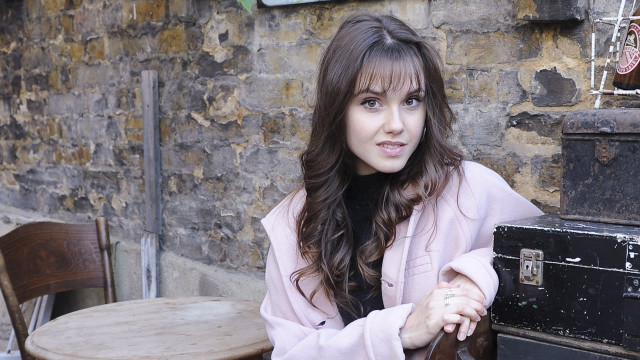 Woman sitting table suitcase brick free wallpaper for desktop - medium preview image