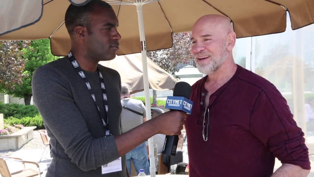 Man holding microphone talking under free wallpaper for desktop - medium preview image