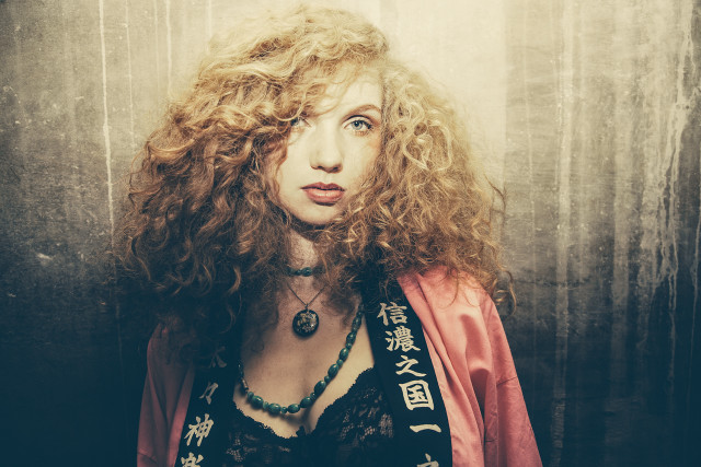Woman curly hair red jacket free wallpaper for desktop - medium preview image