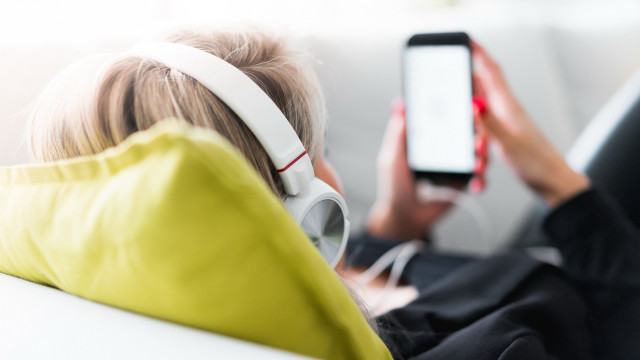 Woman couch headphones yellow jacket free wallpaper for desktop - medium preview image