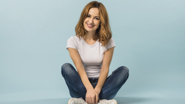 Woman sitting smiling blue background free wallpaper for desktop - medium preview image