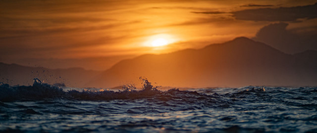 Sunset ocean wave mountains boat free wallpaper for desktop - medium preview image