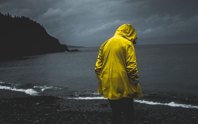 Man yellow raincoat beach ocean free wallpaper for desktop - medium preview image