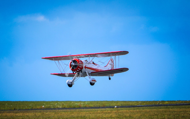 Red white plane flying grass free wallpaper for desktop - medium preview image