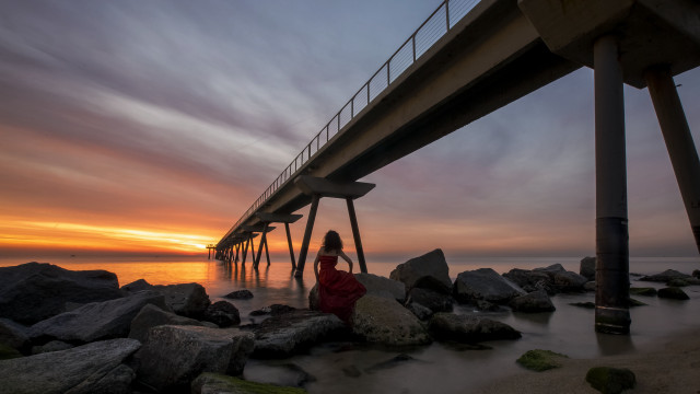 Woman rocks bridge sunset ocean free wallpaper for desktop - medium preview image