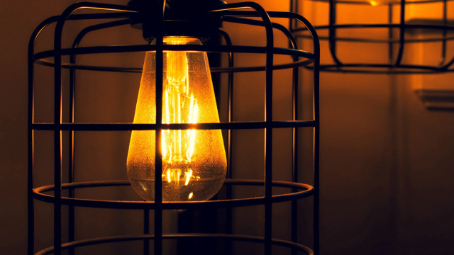 Lit bulb in caged fixture free wallpaper for desktop - medium preview image