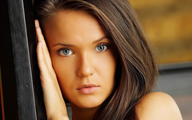 Blue eyes woman leaning wall free wallpaper for desktop - medium preview image