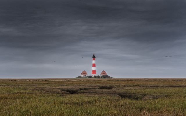 Lighthouse grassy island cloudy sky free wallpaper for desktop - medium preview image