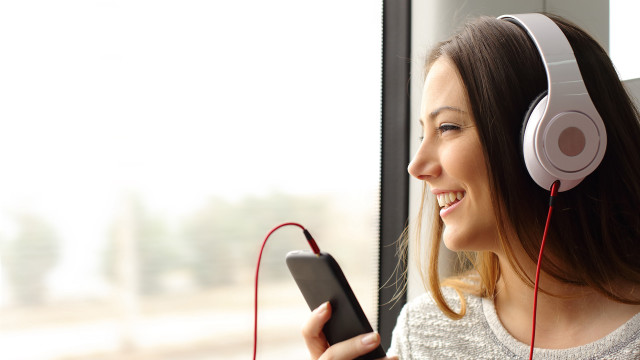 Woman headphones smiling train cellphone free wallpaper for desktop - medium preview image