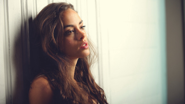 Woman leaning wall serious portrait #5 free wallpaper for desktop - medium preview image