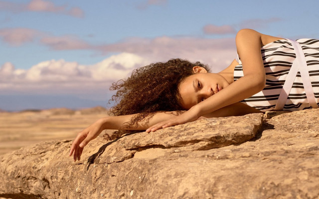Woman rock stretching arm beach free wallpaper for desktop - medium preview image