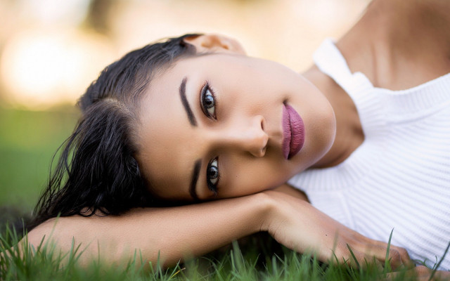 Woman laying on grass blurry free wallpaper for desktop - medium preview image