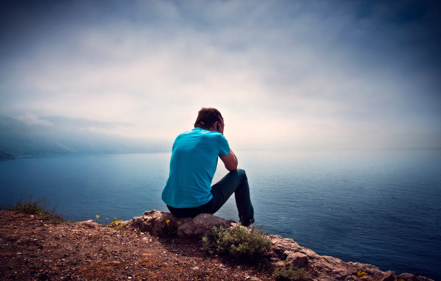 Man sitting rock ocean cloudy #2 free wallpaper for desktop - medium preview image