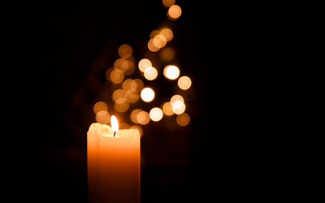 Lit candle blurry lights dark free wallpaper for desktop - medium preview image