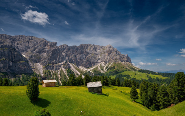 Grassy field cabins mountains clouds free wallpaper for desktop - medium preview image