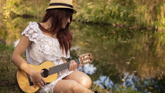 Woman playing guitar outdoors nature free wallpaper for desktop - medium preview image