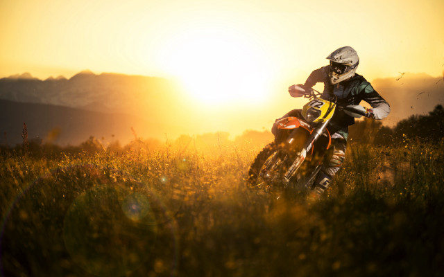 Dirt bike riding grassy field free wallpaper for desktop - medium preview image
