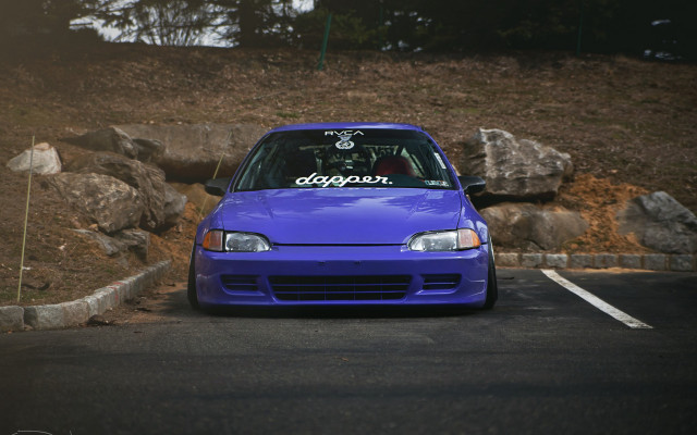 Blue car parked rock wall free wallpaper for desktop - medium preview image