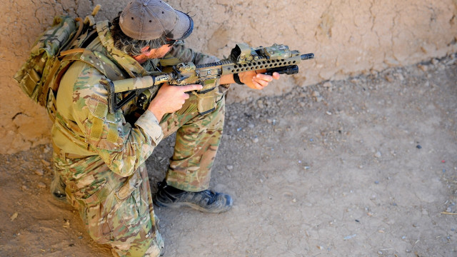 Soldier gun helmet sitting wall free wallpaper for desktop - medium preview image