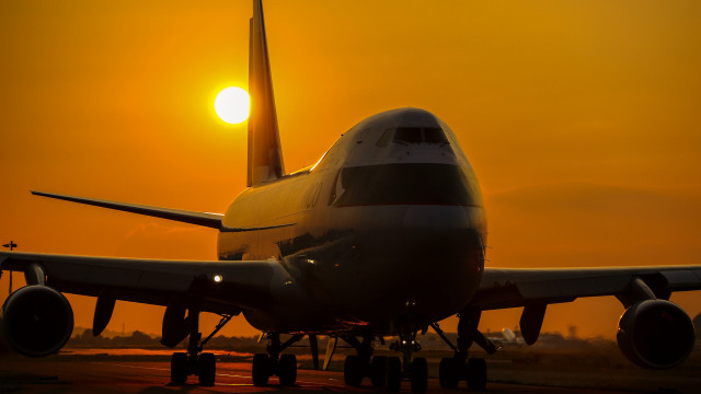 Large jetliner sunset runway backlit free wallpaper for desktop - medium preview image