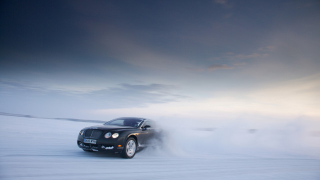 Black car driving snowfield cloudy free wallpaper for desktop - medium preview image