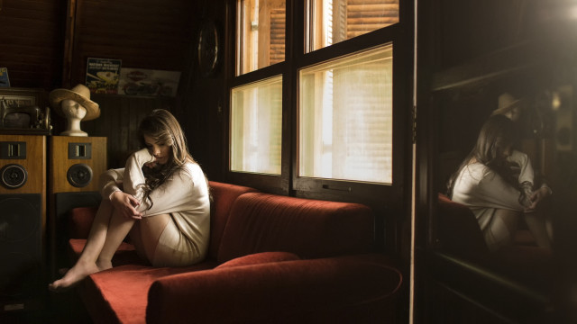 Woman sitting red couch indoor free wallpaper for desktop - medium preview image