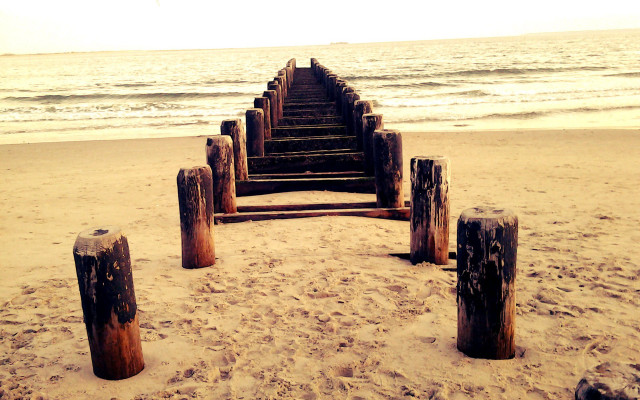 Wooden posts beach waves sunset free wallpaper for desktop - medium preview image