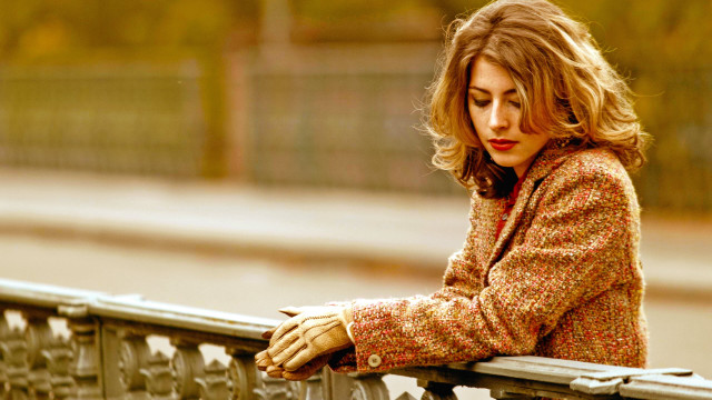 Woman leaning rail blonde blurry free wallpaper for desktop - medium preview image