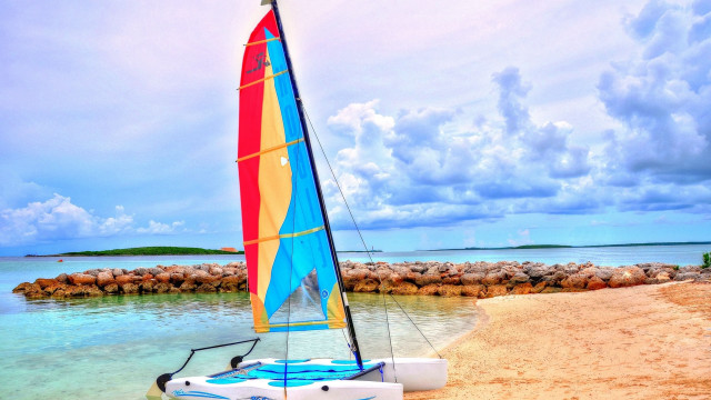 Sailboat beach rockwall person sunset free wallpaper for desktop - medium preview image