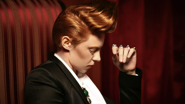 Redhair woman blackjacket handsface lookingdown free wallpaper for desktop - medium preview image