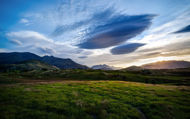 Grassy field mountains sunset clouds free wallpaper for desktop - medium preview image