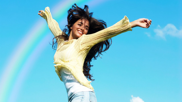 Cheerful woman jumping rainbow blue free wallpaper for desktop - medium preview image
