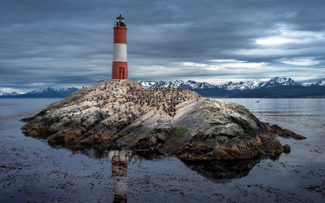 Lighthouse rock ocean mountains cloudy free wallpaper for desktop - medium preview image
