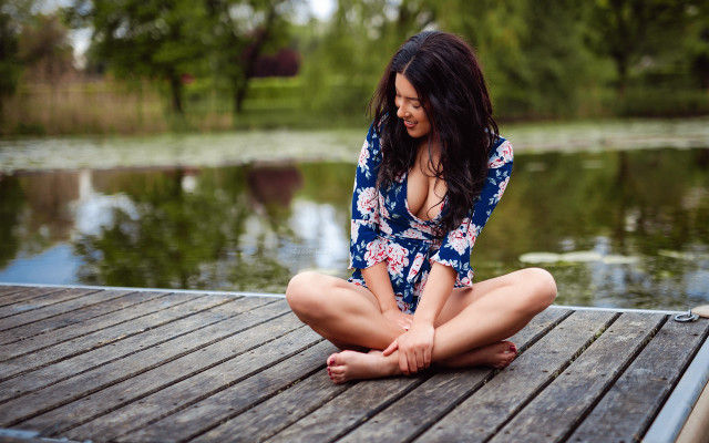 Woman sitting dock water blurry free wallpaper for desktop - medium preview image