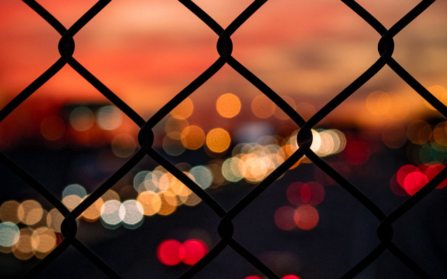 Blurry city night fence chainlink free wallpaper for desktop - medium preview image